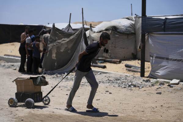 A Palestinian man carries humanitarian aid delivered by the U.S.-backed Gaza Humanitarian Foundation, after receiving the supplies in Rafah, as he arrive in Khan Younis, southern Gaza Strip, on Wednesday, May 28, 2025. (AP Photo/Abdel Kareem Hana)