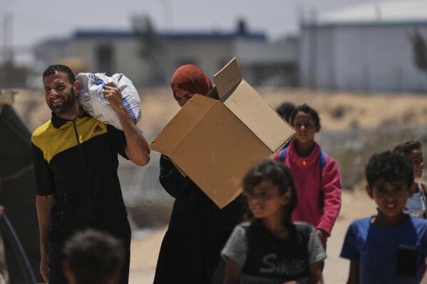 Palestinians carry boxes of food and humanitarian aid delivered by the U.S.-backed Gaza Humanitarian Foundation, after receiving the supplies in Rafah, as they arrive in Khan Younis, southern Gaza Strip, on Wednesday, May 28, 2025. (AP Photo/Abdel Kareem Hana)
