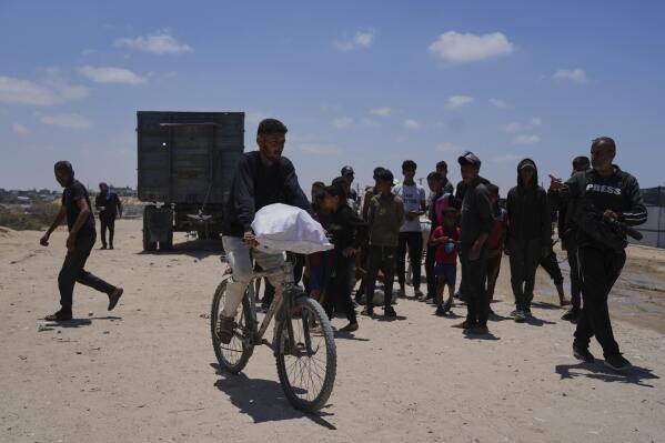 Palestinians carry food and humanitarian aid delivered by the U.S.-backed Gaza Humanitarian Foundation, after receiving the supplies in Rafah, as they arrive in Khan Younis, southern Gaza Strip, on Wednesday, May 28, 2025. (AP Photo/Abdel Kareem Hana)